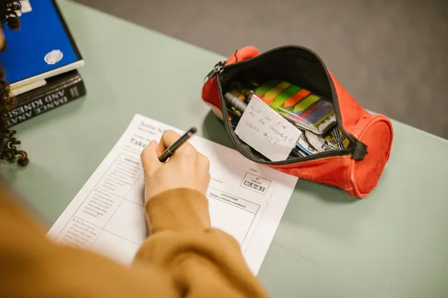A college student using cheat notes during an exam with visible test paper and pencil case. Seven checks in a B2B influencer marketing supplier comparison