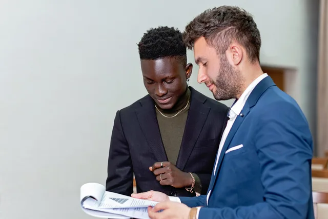 Two businessmen reviewing documents together, engaged in a professional discussion. How to define a B2B influencer marketing target audience